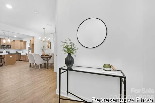 a living room with furniture a mirror and a potted plant