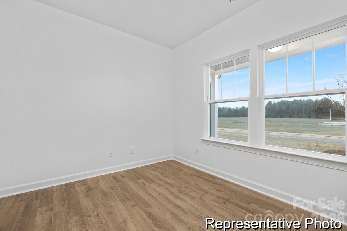 155 Soft Breeze Bend, Unit 286B Locust, NC 28097 - Photo 24 of 28 an empty room with wooden floor and windows