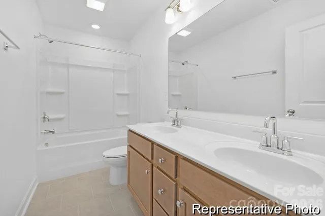 a bathroom with a sink a toilet a mirror a bathtub and shower