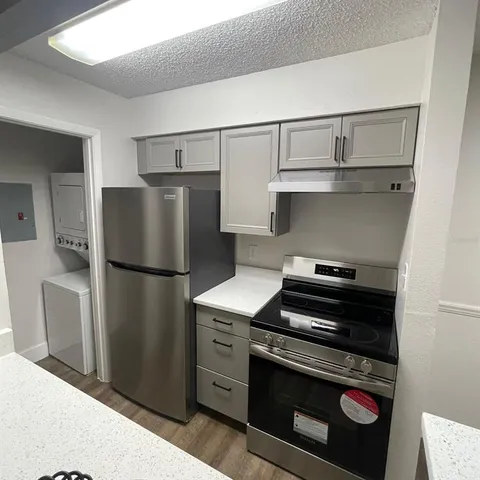a kitchen with a refrigerator and a stove top oven
