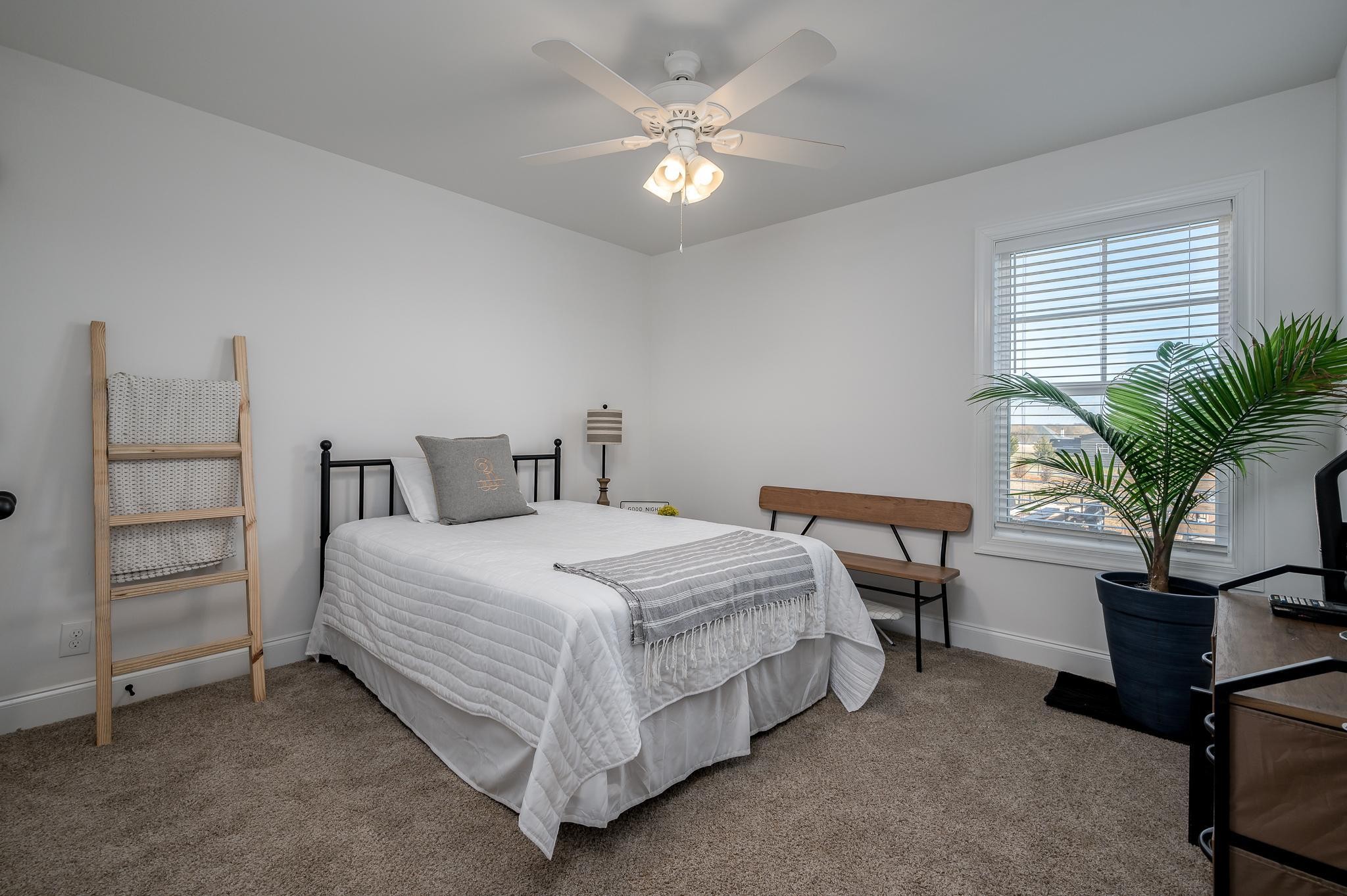 105 Autumn Cove Road Bell Buckle, TN 37020 - Photo 14 of 32 a bedroom with a bed and a potted plant