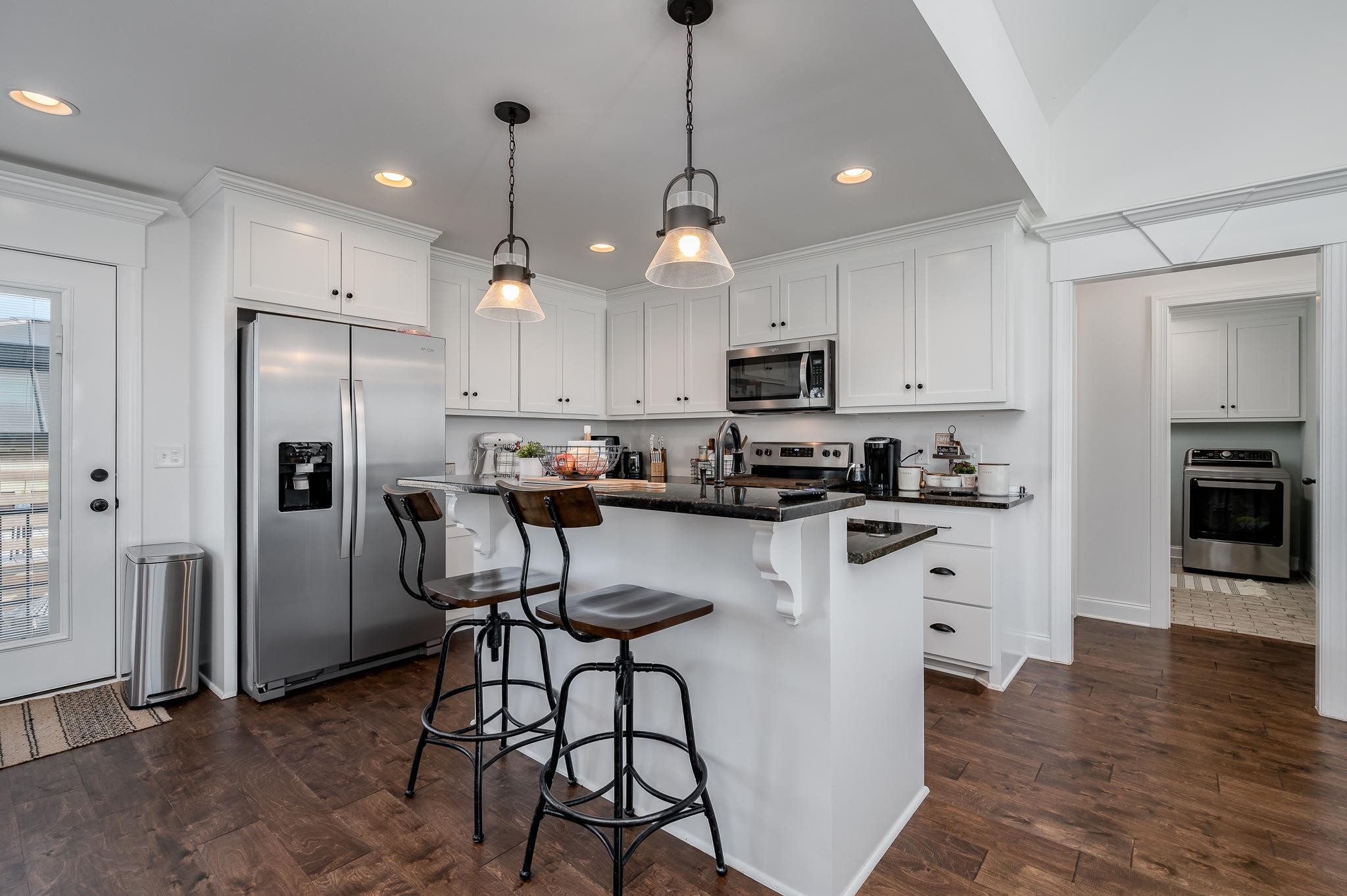 105 Autumn Cove Road Bell Buckle, TN 37020 - Photo 10 of 32 a kitchen with refrigerator a stove a sink and white cabinets with wooden floor