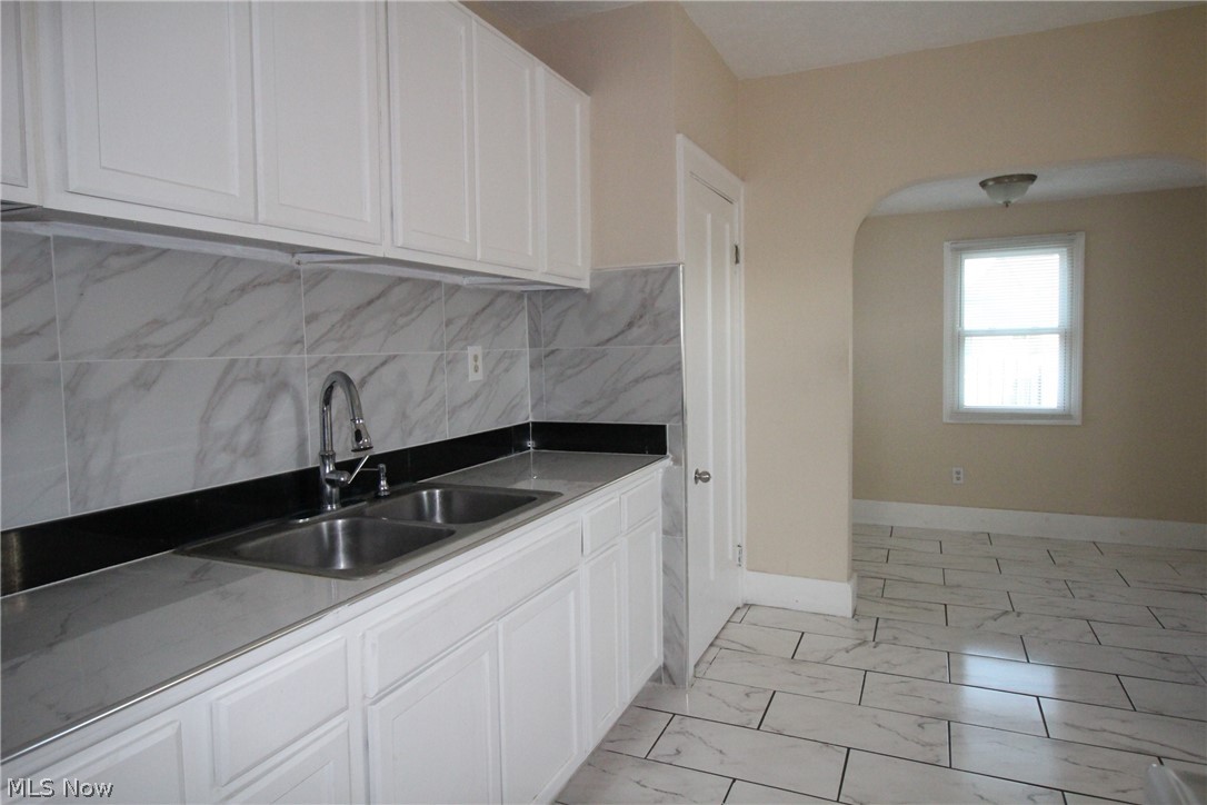 5757 Pearl Road Parma, OH 44129 - Photo 10 of 25 Kitchen featuring white cabinetry, a dual basin stainless steel sink with a high-arc faucet, and light-toned countertops