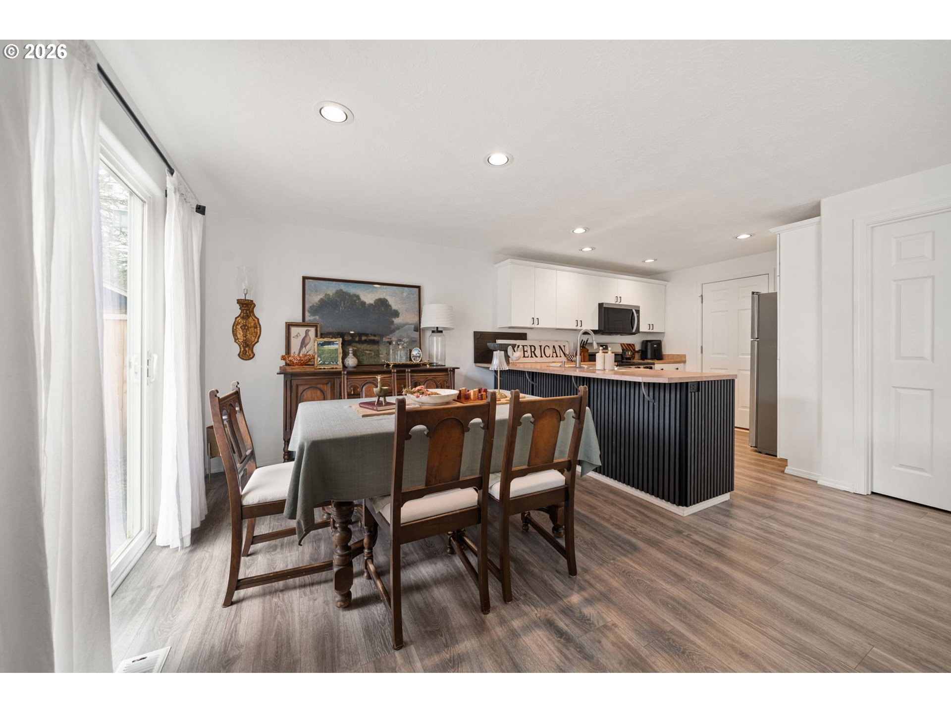 15902 Dreamcatcher Avenue Sandy, OR 97055 - Photo 12 of 32 a open dining room with stainless steel appliances kitchen island granite countertop a table chairs and a refrigerator