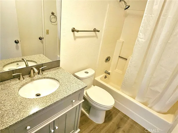 a bathroom with a granite countertop toilet sink and mirror