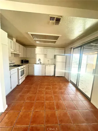 a room with lots of wooden cabinets and a stainless steel appliances