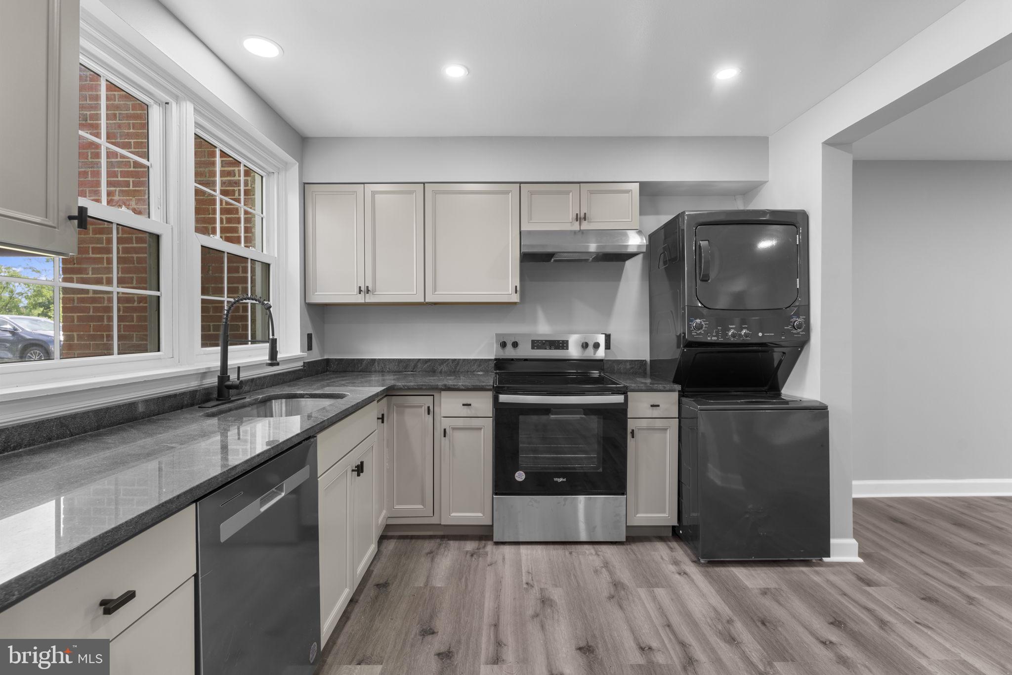 1044 A Ramsgate Court Sterling, VA 20164 - Photo 5 of 20 a kitchen with stainless steel appliances granite countertop a stove a sink and a granite counter tops with wooden floors