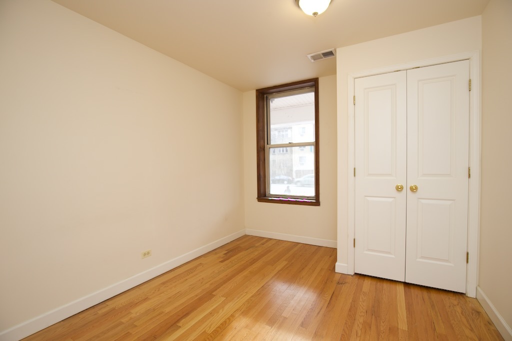 6713 North Sheridan Road, Unit 2N Chicago, IL 60626 - Photo 9 of 20 an empty room with wooden floor and windows