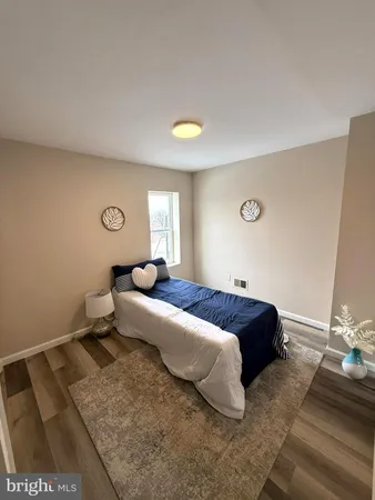 a spacious bedroom with a bed and a lamp