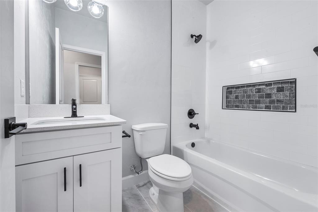 6703 Southwest 10th Lane Gainesville, FL 32607 - Photo 11 of 33 a bathroom with a sink a toilet and shower