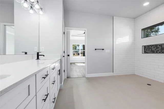 a bathroom with a double vanity sink a toilet and a mirror