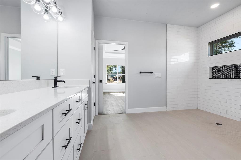 6703 Southwest 10th Lane Gainesville, FL 32607 - Photo 17 of 33 a bathroom with a double vanity sink a toilet and a mirror