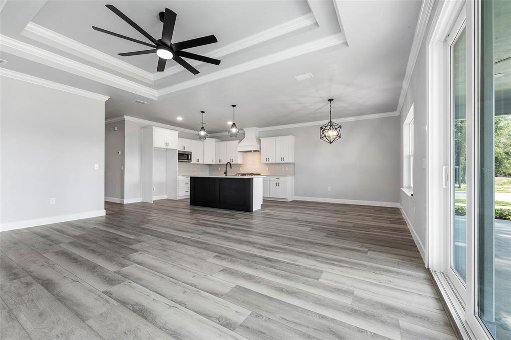 6703 Southwest 10th Lane Gainesville, FL 32607 - Photo 18 of 33 a view of a livingroom with a ceiling fan wooden floor and a ceiling fan