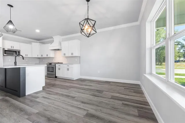 a kitchen with white cabinets stainless steel appliances and sink