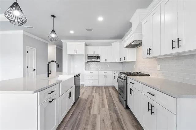 a kitchen with kitchen island a sink and a stove top oven