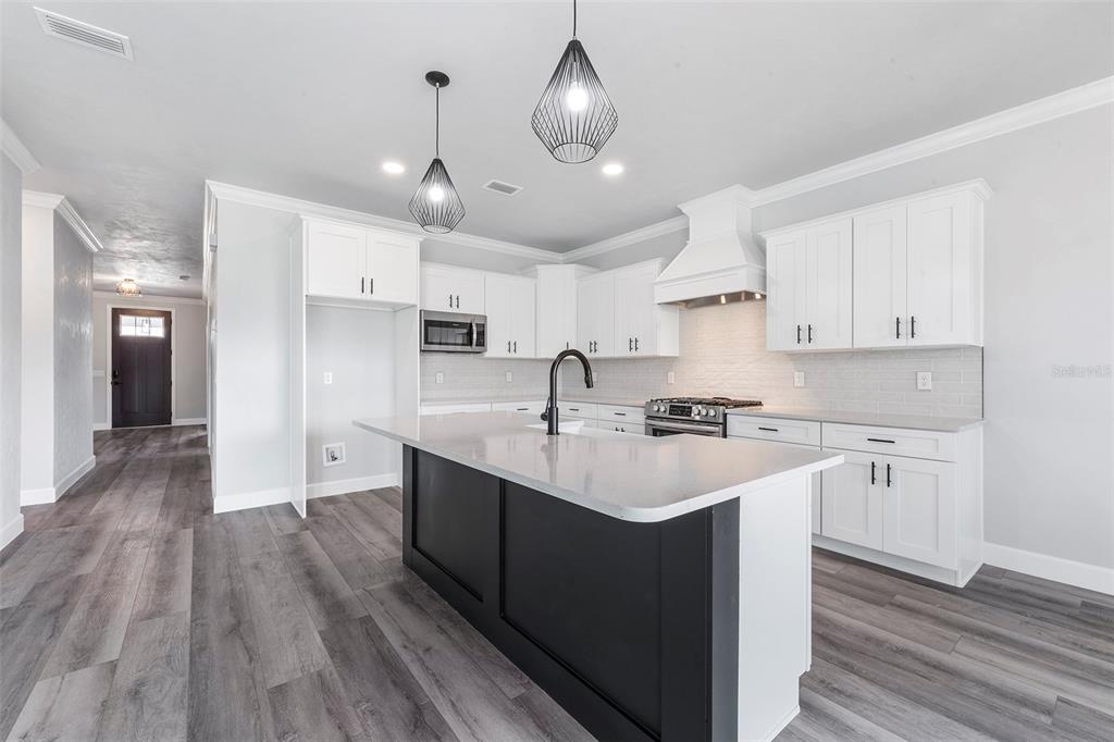 6703 Southwest 10th Lane Gainesville, FL 32607 - Photo 23 of 33 a kitchen with kitchen island a sink and a stove top oven