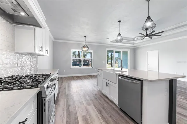 a kitchen with granite countertop a sink stove and cabinets