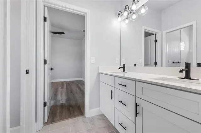 a bathroom with double vanity sink and a mirror