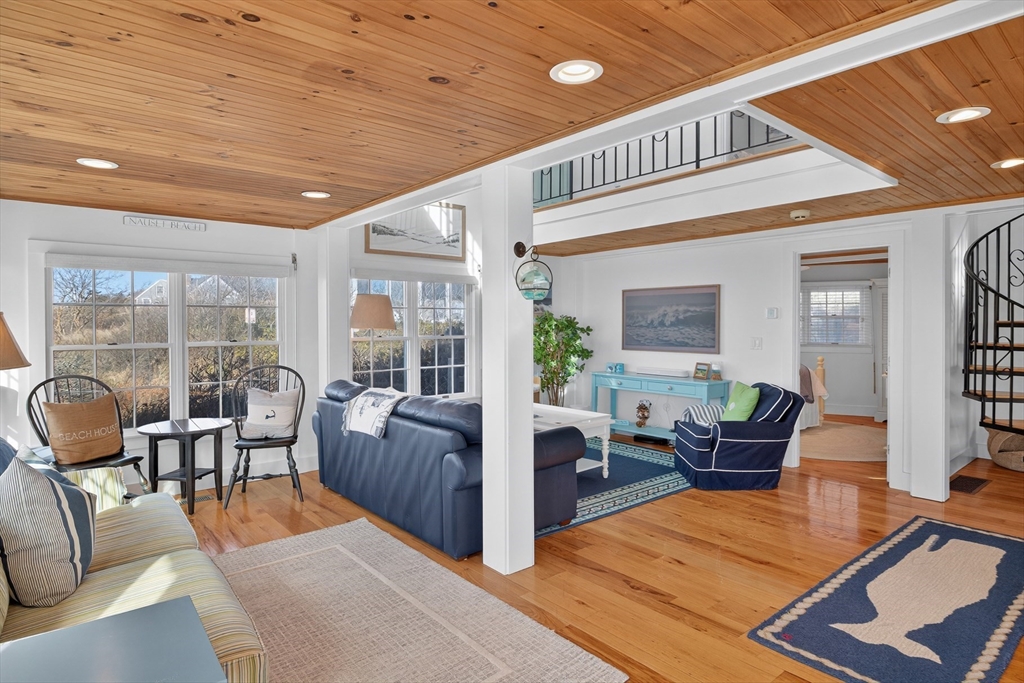 1145 Kingsbury Beach Road Eastham, MA 02642 - Photo 26 of 42 a living room with furniture large windows and wooden floor