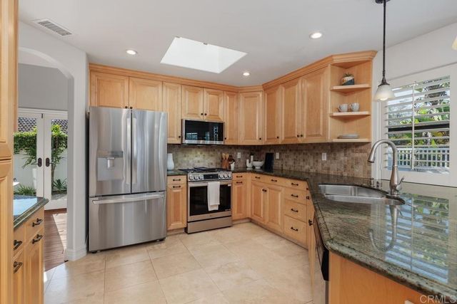 a kitchen with stainless steel appliances granite countertop a refrigerator a stove top oven a sink and dishwasher