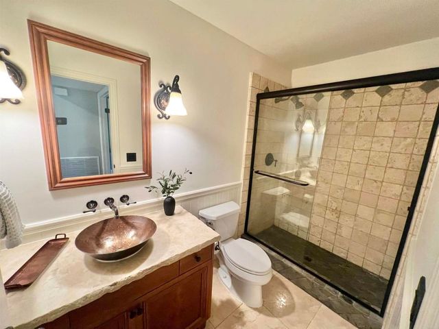 a bathroom with a granite countertop sink toilet a mirror and shower