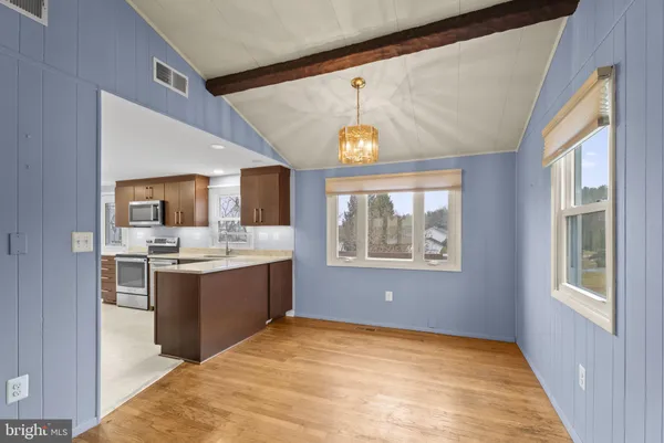 a kitchen with kitchen island granite countertop a sink cabinets and stainless steel appliances
