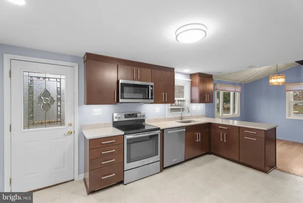 a kitchen with a sink a stove top oven and refrigerator
