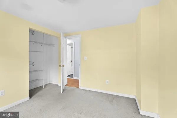 an empty room with ceiling fan and windows