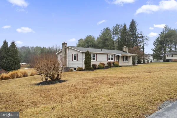 a front view of house with yard and trees around