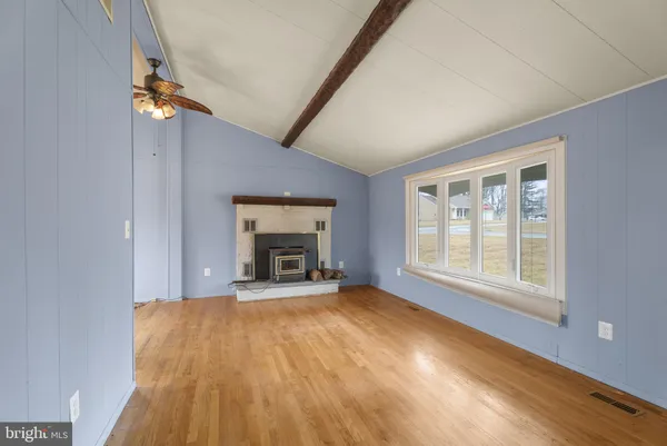 an empty room with a fireplace and window
