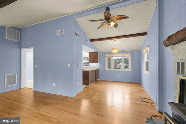 a view of a livingroom with a chandelier fan and wooden floor