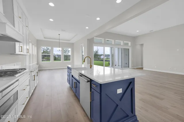 a kitchen with stainless steel appliances granite countertop a stove and a wooden floors