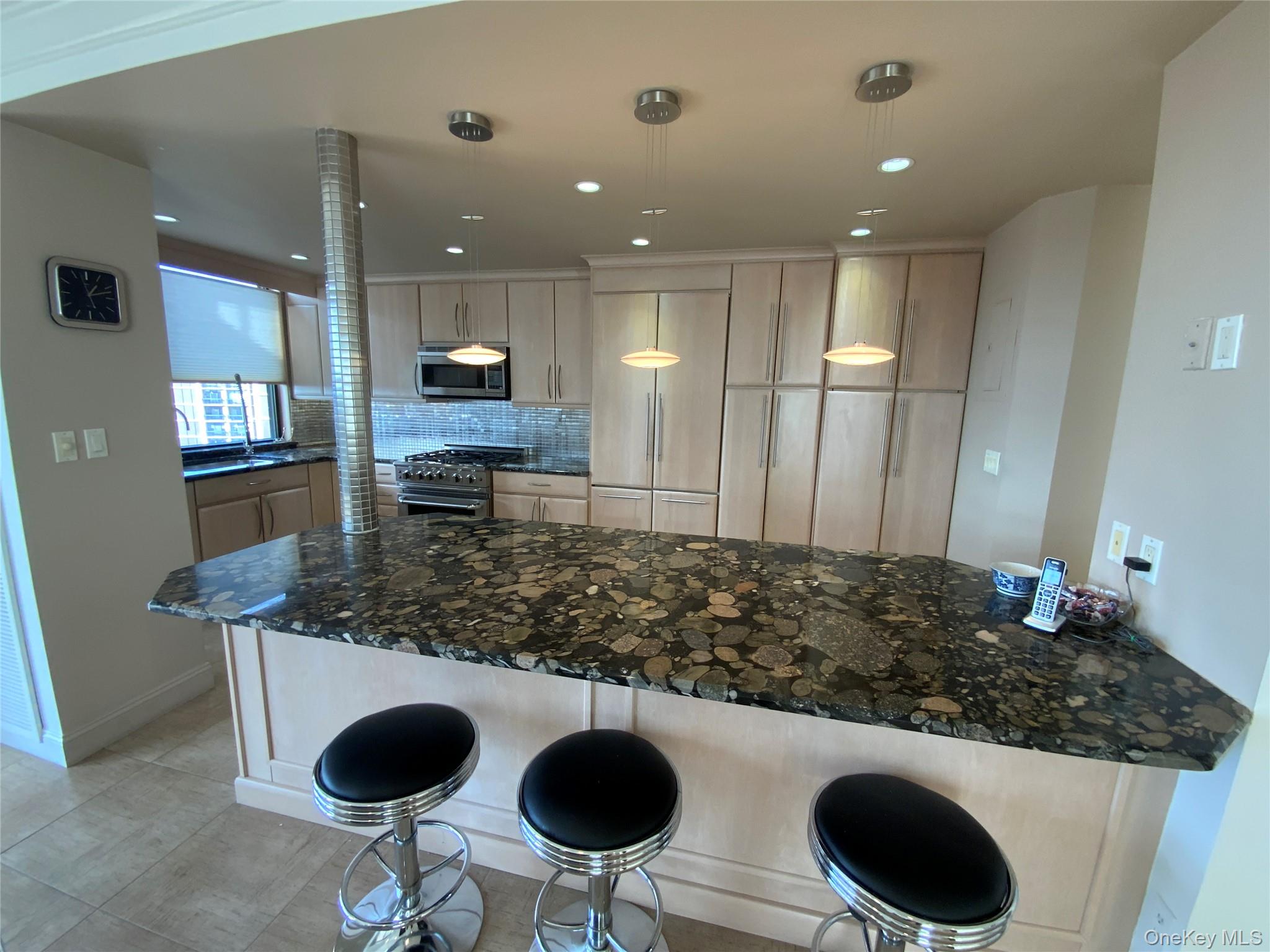 269 Grand Central Parkway, Unit 32O Queens, NY 11005 - Photo 8 of 33 a kitchen with kitchen island stainless steel appliances a sink and a stove