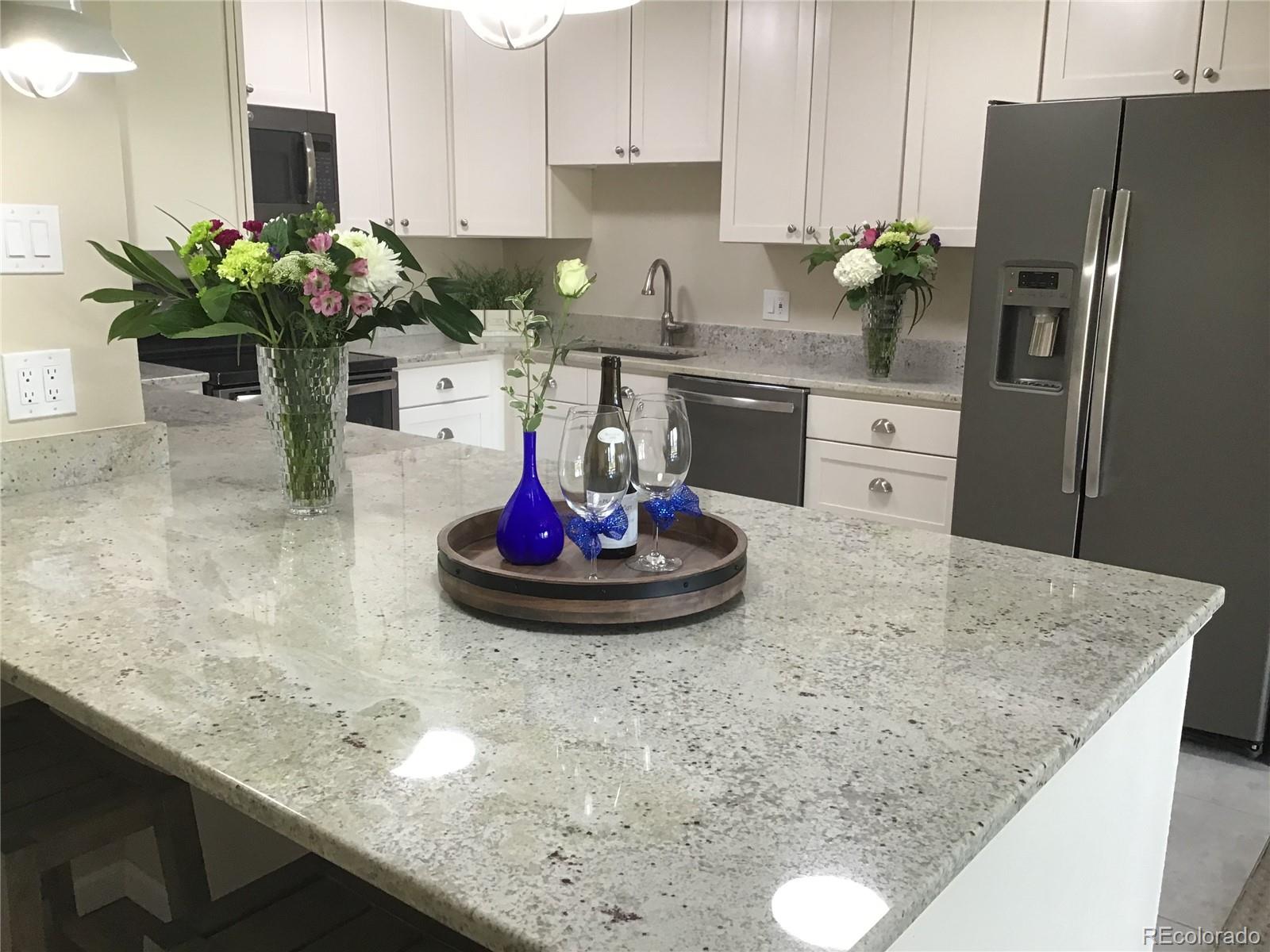 a kitchen with a sink a refrigerator and cabinets