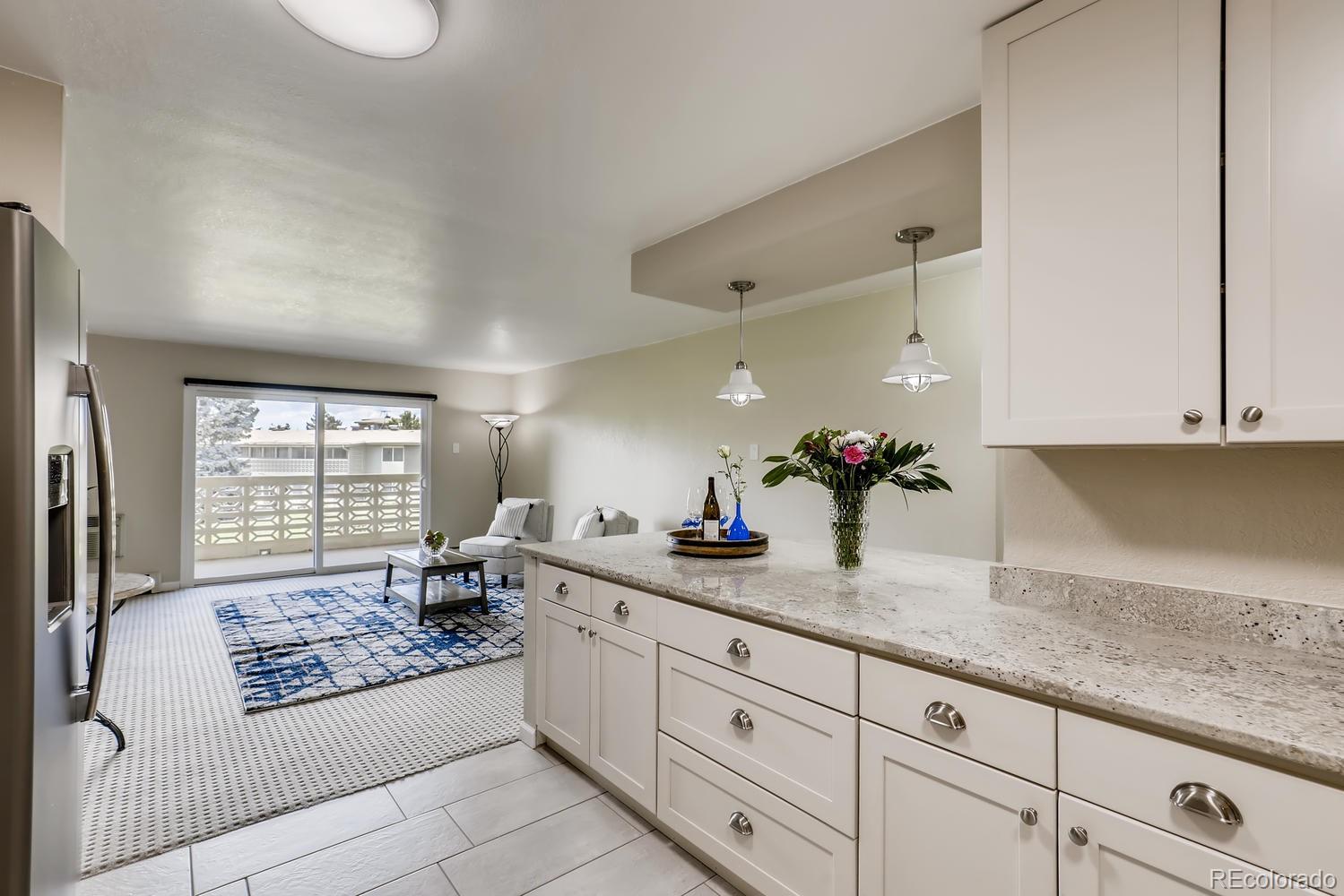 9340 Center Avenue, Unit 6B Denver, CO 80247 - Photo 11 of 40 a spacious bathroom with a granite countertop sink mirror and a bathtub