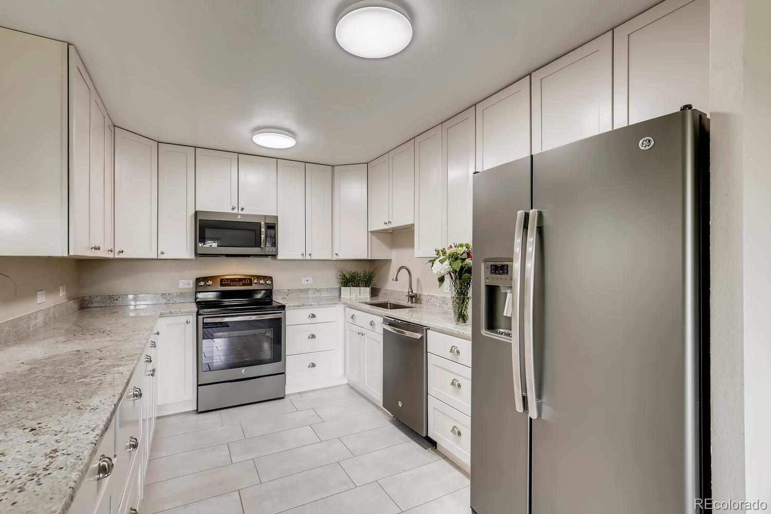 9340 Center Avenue, Unit 6B Denver, CO 80247 - Photo 14 of 40 a kitchen with stainless steel appliances granite countertop a refrigerator stove a sink and dishwasher