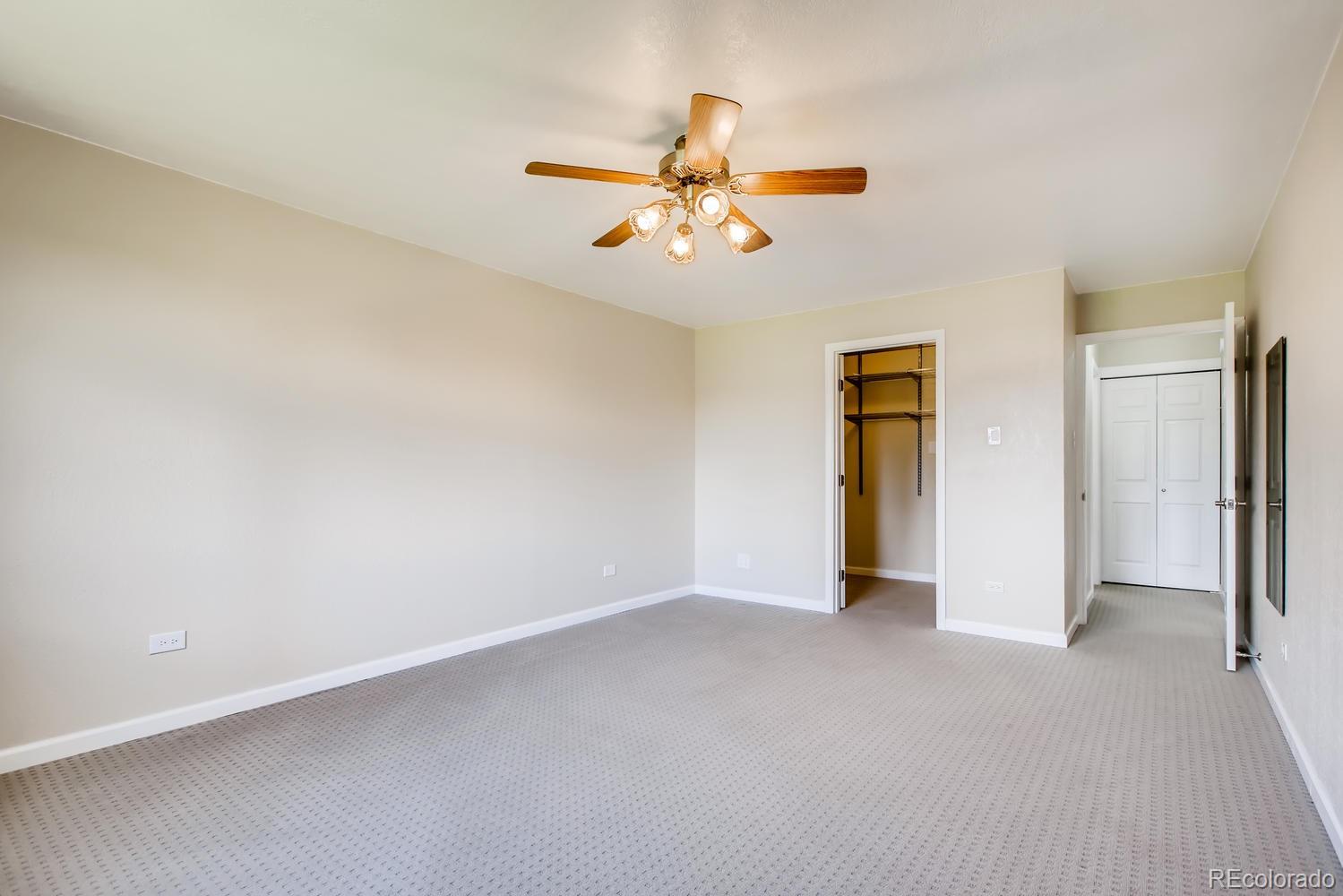 9340 Center Avenue, Unit 6B Denver, CO 80247 - Photo 21 of 40 an empty room with closet and a chandelier fan