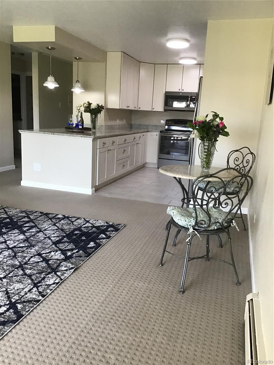 9340 Center Avenue, Unit 6B Denver, CO 80247 - Photo 5 of 40 a kitchen with stainless steel appliances granite countertop a stove a sink and a microwave