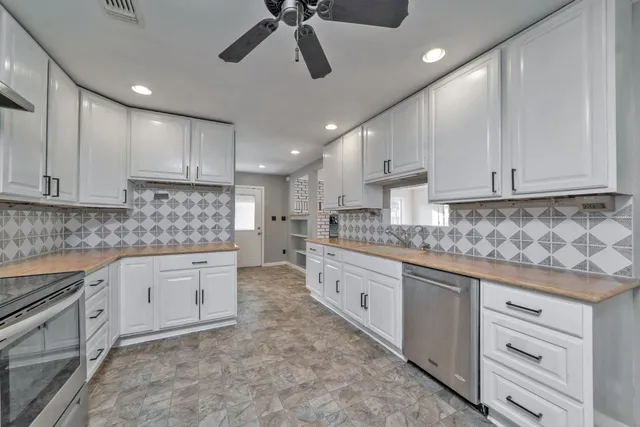 a kitchen with white cabinets and white appliances