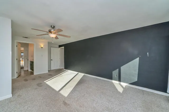 a view of an empty room with glass door and balcony