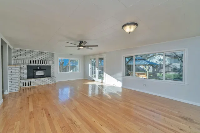wooden floor fireplace and windows in an empty room