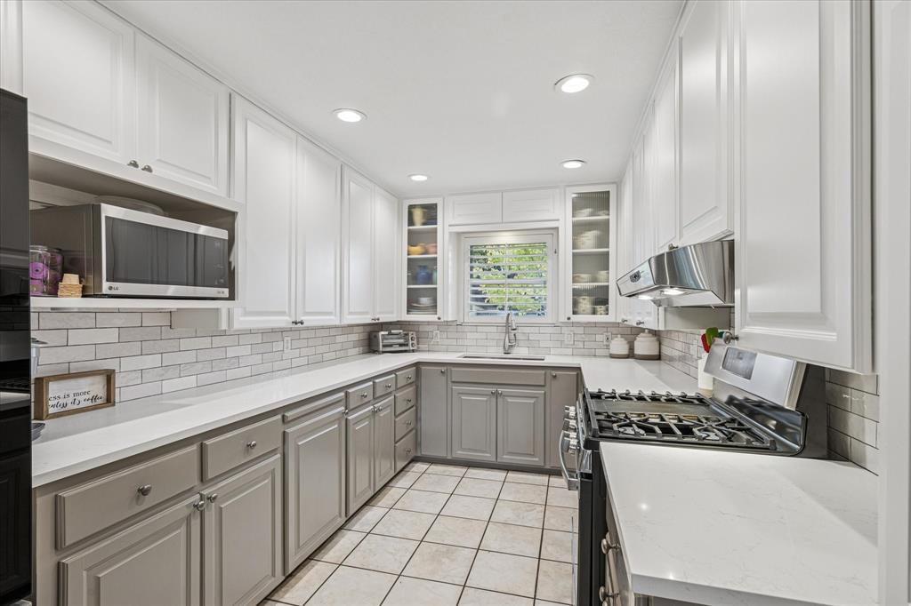 4209 Bilglade Road Fort Worth, TX 76109 - Photo 12 of 24 a kitchen with stainless steel appliances a sink stove and cabinets
