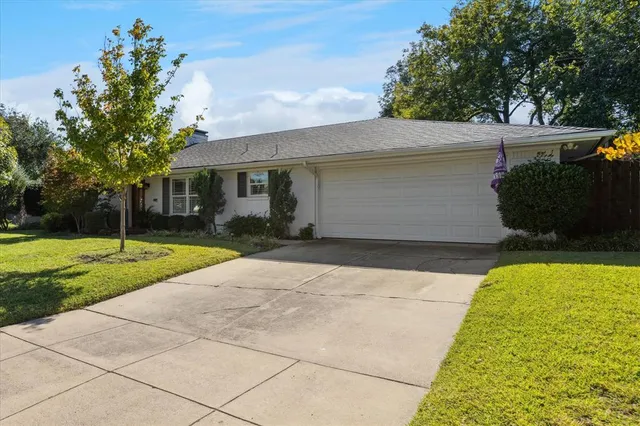 a front view of house with yard and trees around