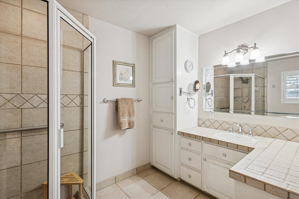 4209 Bilglade Road Fort Worth, TX 76109 - Photo 21 of 24 a spacious bathroom with a granite countertop sink a mirror and shower