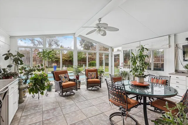 a living room with patio furniture and a potted plant