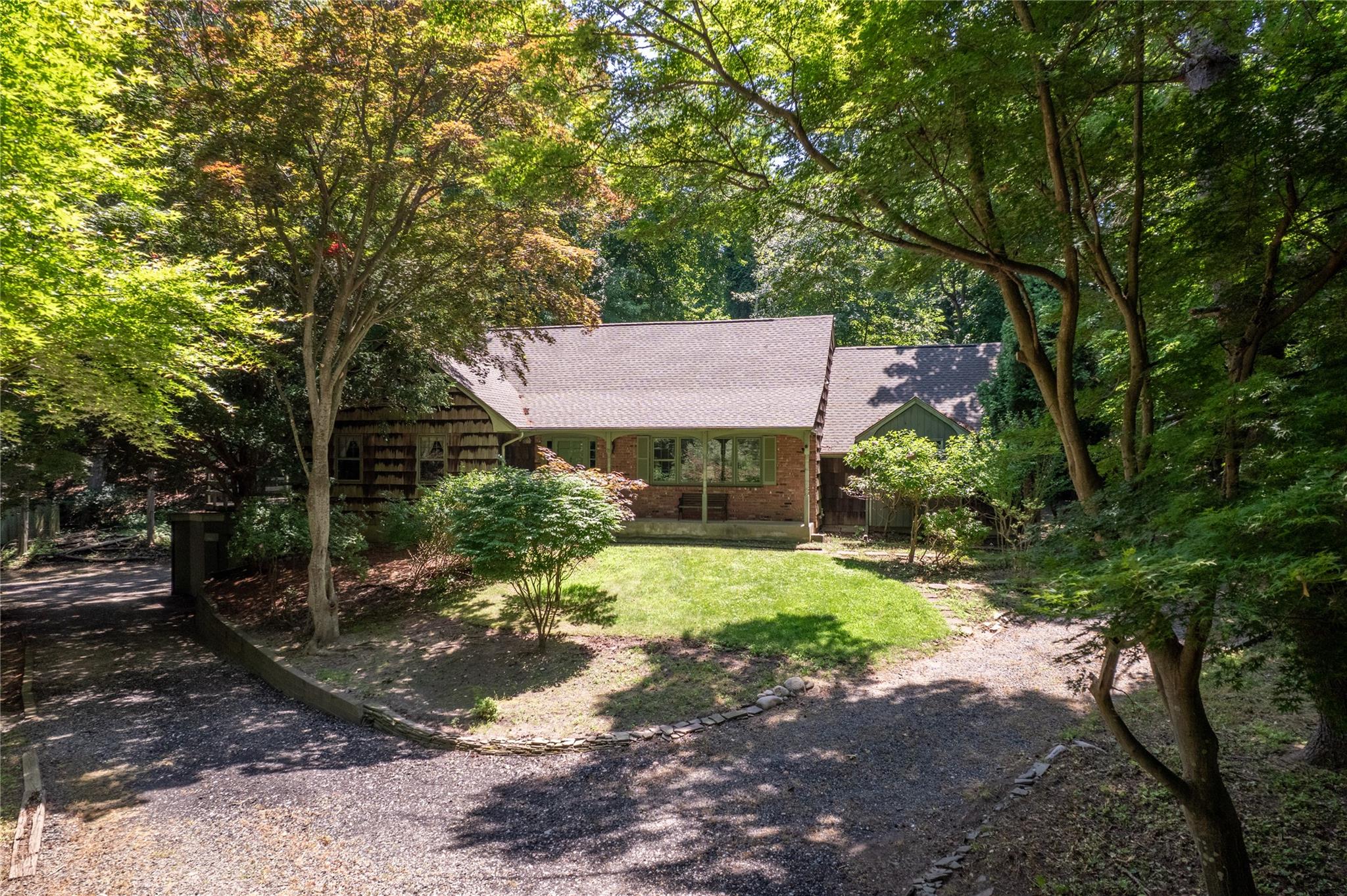 View of front facade with a shingled roof and a front lawn