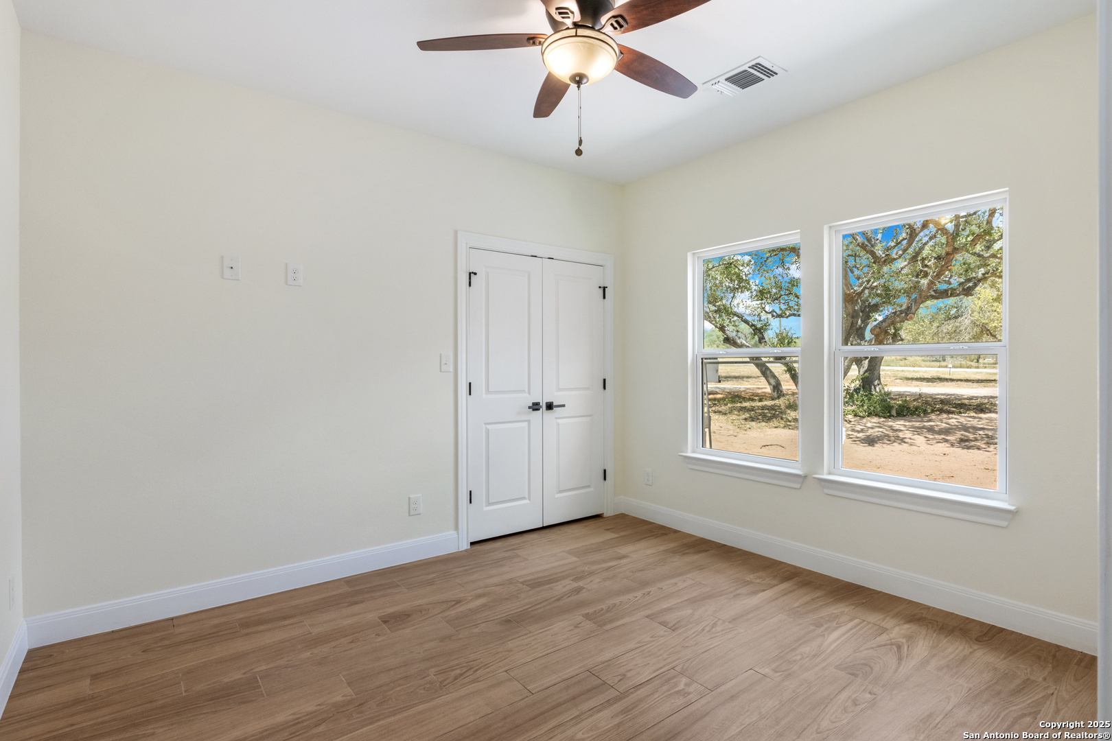 32 Trophy Lane Poteet, TX 78065 - Photo 14 of 47 an empty room with wooden floor fan and windows