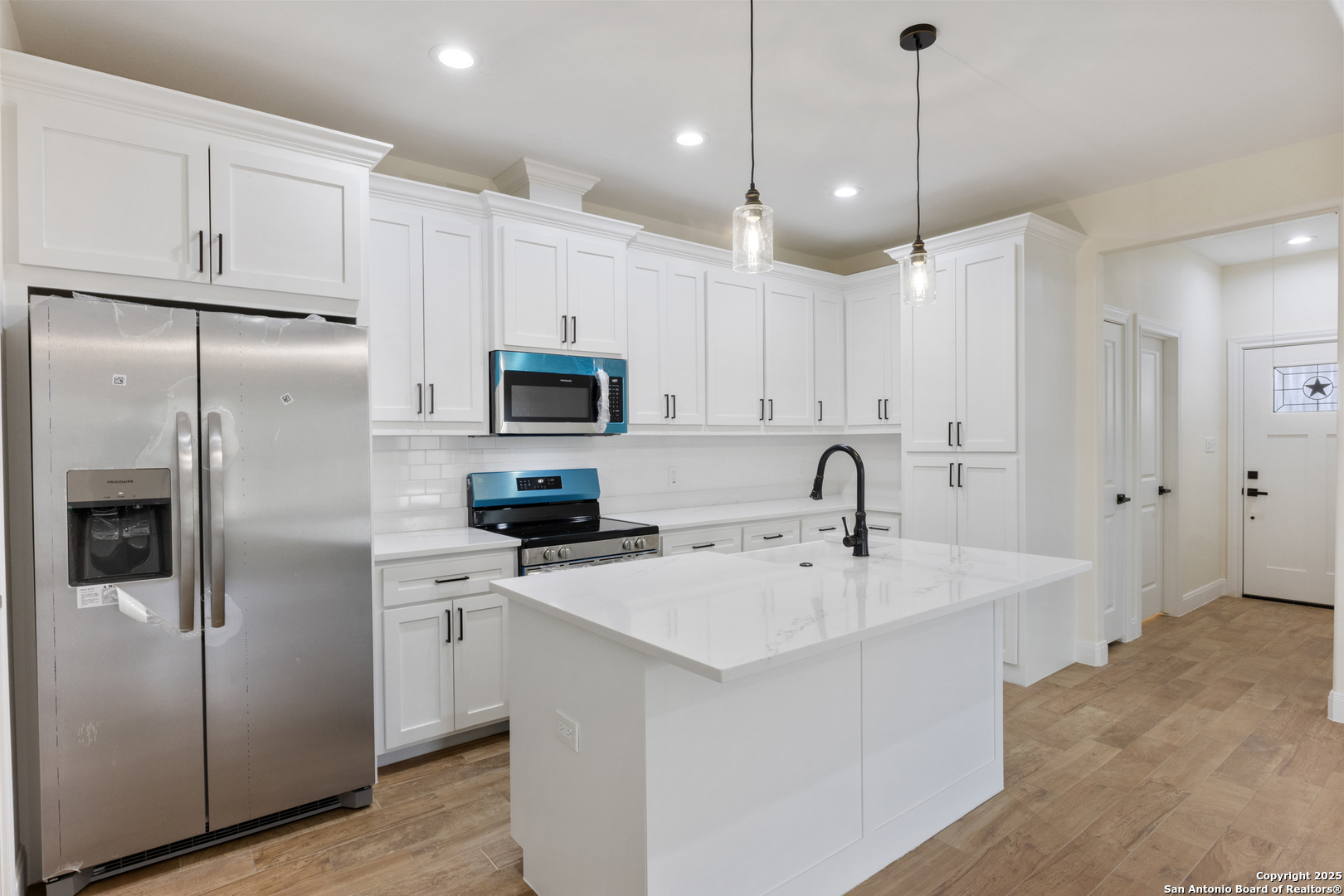 32 Trophy Lane Poteet, TX 78065 - Photo 32 of 47 a kitchen with white cabinets and stainless steel appliances