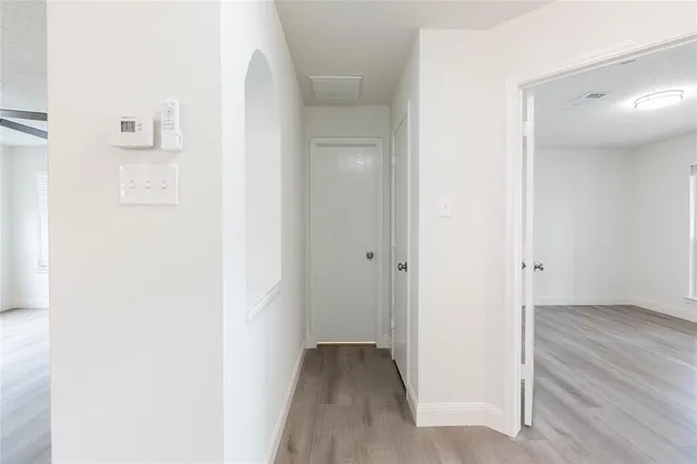 a view of a hallway with wooden floor