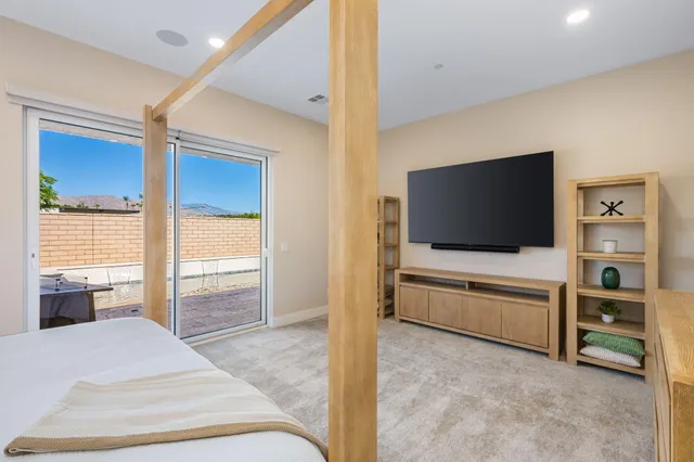 a living room with flat screen tv and floor to ceiling window
